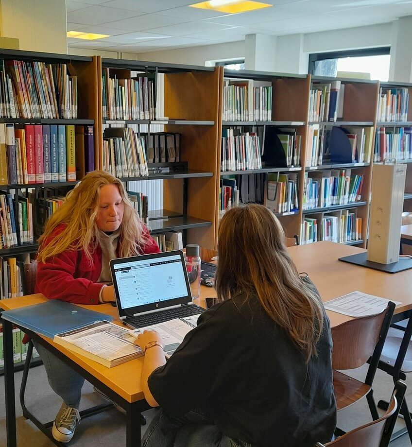 Twee studenten aan tafel in leercentrum